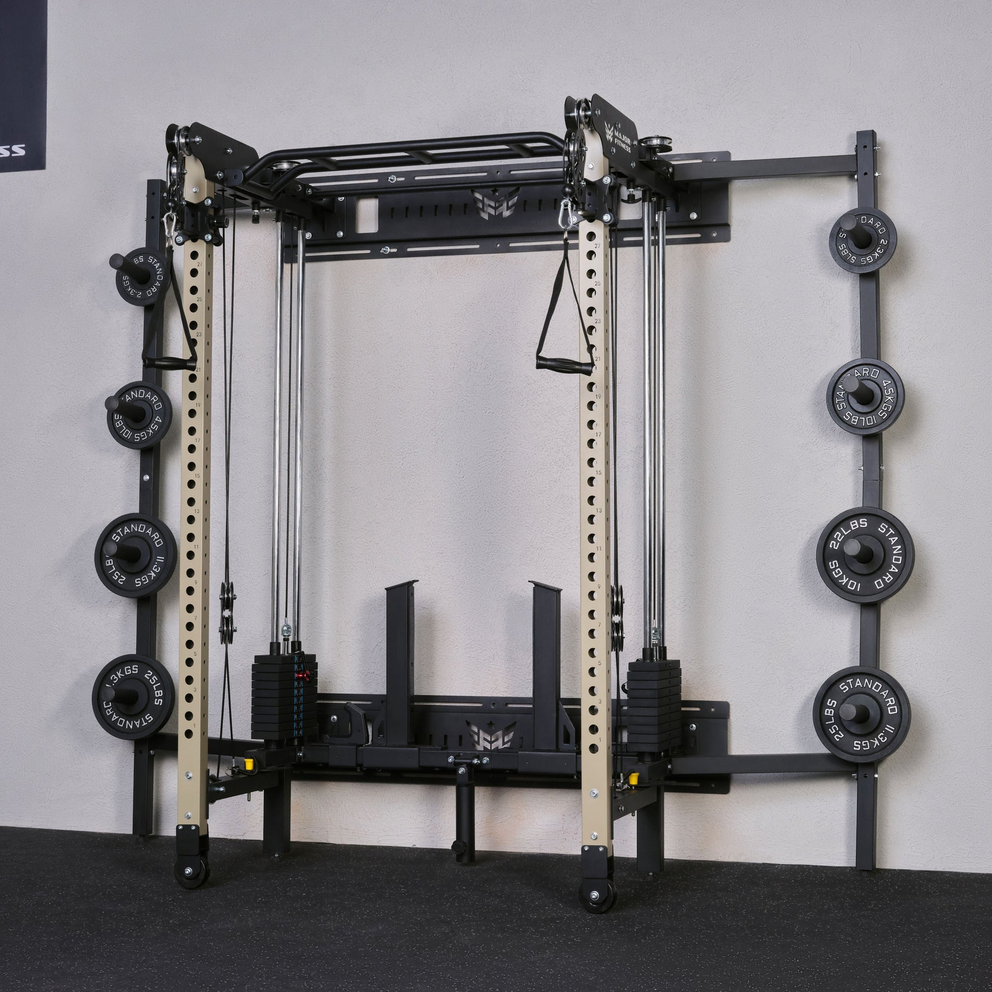 Gym equipment with weight plates on a gray floor against a white wall.